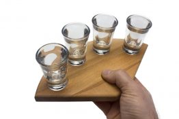 Kleines Schnapsglasträger aus Holz in der Hand